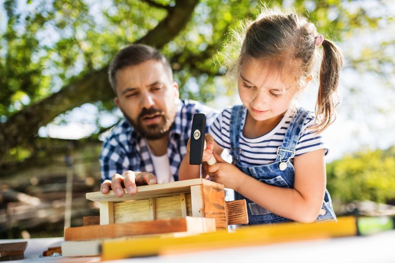 Père avec fille construisent un nid pour oiseau du jardin